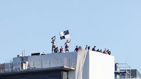 Hinchas de Colo Colo ven el partido en la azotea de un edificio.
