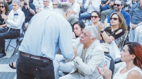 Carlos Caszely y Axel Pickett se estrechan en un saludo afectuoso
