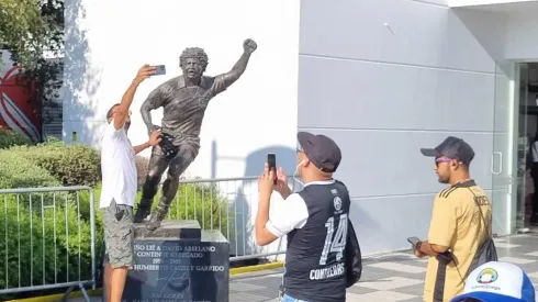 Los hinchas quieren su foto junto a la estatua del ídolo.