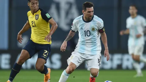 Messi traslada la pelota. Detrás suyo, Caicedo intenta contenerlo.