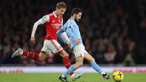 LONDON, ENGLAND – FEBRUARY 15: Bernardo Silva of Manchester City runs with the ball whilst under pressure from Martin Odegaard of Arsenal during the Premier League match between Arsenal FC and Manchester City at Emirates Stadium on February 15, 2023 in London, England. (Photo by Julian Finney/Getty Images)
