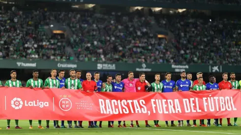 SEVILLE, SPAIN – MAY 24: Players from both teams and match officials pose for a photo with a banner against racism prior to the LaLiga Santander match between Real Betis and Getafe CF at Estadio Benito Villamarin on May 24, 2023 in Seville, Spain. (Photo by Fran Santiago/Getty Images)
