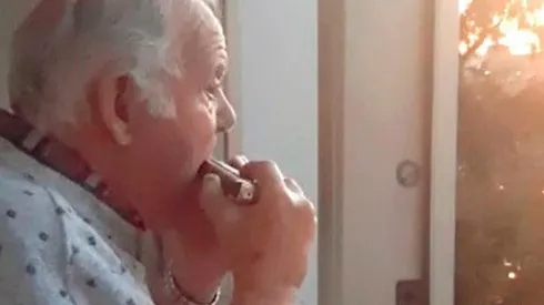 Hermann, de 80 años, da un concierto de armónica desde el balcón de su departamento.