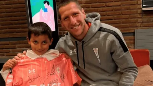 El pequeño Luciano compartiendo con Aued, con el regalo de la camiseta de Universidad Católica.