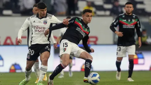 Vicente Fernández disputa un balón con Alexander Oroz en un partido entre Colo Colo y Palestino.
