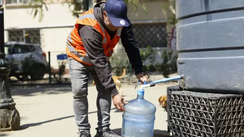 Una persona llega hasta un punto de abastecimiento de la comuna de Santiago, producto del megacorte de agua.