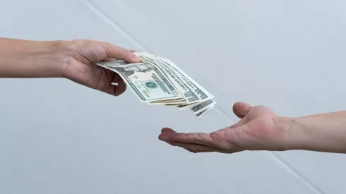 Una persona entrega dinero a otra