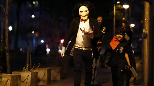 Niños disfrutan la noche de Halloween pidiendo dulces junto a sus padres en la comuna de Santiago.