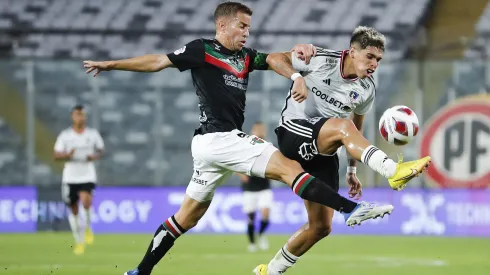 Agustín Farís disputa un balón con Carlos Palacios en un partido entre Colo Colo y Palestino.