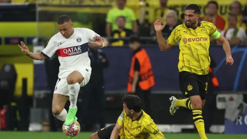 Mbappé lucha contra dos jugadores de Borussia Dortmund.