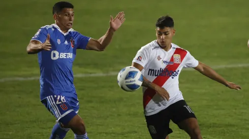 Yerko Leiva en acción por Curicó Unido: protege el balón ante Israel Poblete, de Universidad de Chile.
