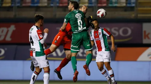 Los jugadores de Audax Italiano y Palestino disputan el balón en el aire.