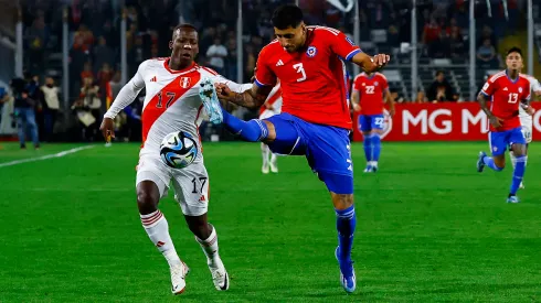 Guillermo Maripán y Luis Advíncula disputan el balón en el último enfrentamiento de Chile y Perú.