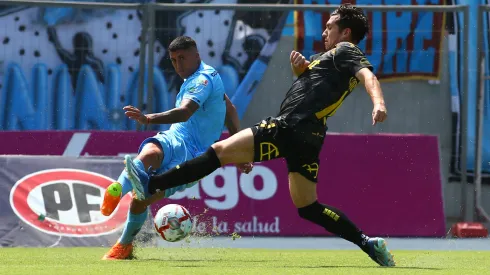 Rubén Farfán manda el centro ante la marca de Juan Cornejo en el partido de Deportes Iquique y Coquimbo Unido, en la primera rueda del Campeonato Nacional 2024.