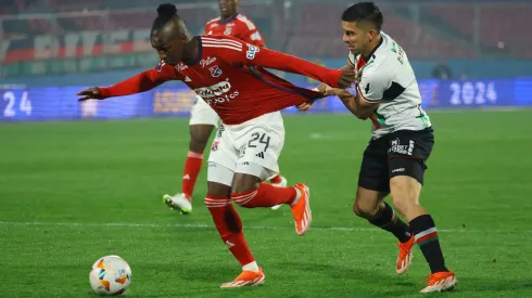 Jonathan Benítez pelea con José Ortiz en el partido entre Palestino e Independiente Medellín.