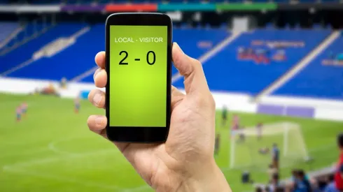 betting man through his smart phone in a stadium