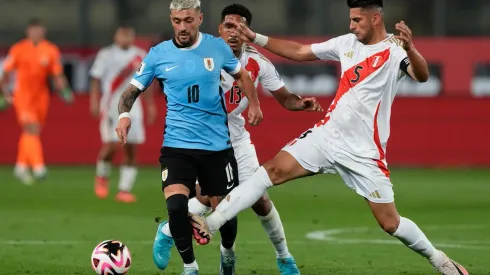 De Arrascaeta disputa a bola na partida entre Peru e Uruguai, no dia 11 de outubro de 2024. (Associated Press / Alamy Stock Photo)
