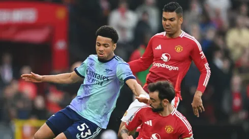 MANCHESTER, ENGLAND – MARCH 09: Ethan Nwaneri of Arsenal is challenged by Bruno Fernandes and Casemiro of Manchester United during the Premier League match between Manchester United FC and Arsenal FC at Old Trafford on March 09, 2025 in Manchester, England. (Photo by Michael Regan/Getty Images)