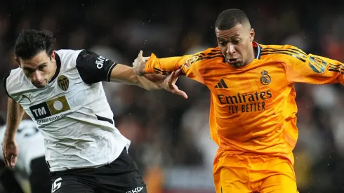 Kylian Mbappé, do Real Madrid, conduz a bola enquanto é pressionado por César Tarrega, do Valencia CF, durante a partida da LaLiga entre Valencia CF e Real Madrid CF, no Estádio Mestalla, em 3 de janeiro de 2025, em Valência, Espanha. (Foto: Aitor Alcalde/Getty Images)