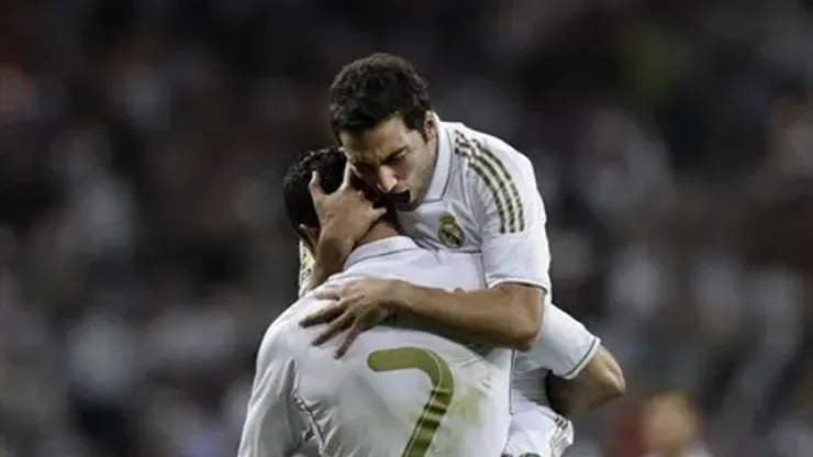 Real Madrid's Gonzalo Higuain from Argentina, top, celebrates after scoring against Getafe with Cristiano Ronaldo from Portugal, bottom, during a Spanish La Liga soccer match at the Santiago Bernabeu stadium in Madrid, Saturday, Sept. 10, 2011. (AP Photo/Arturo Rodriguez)
