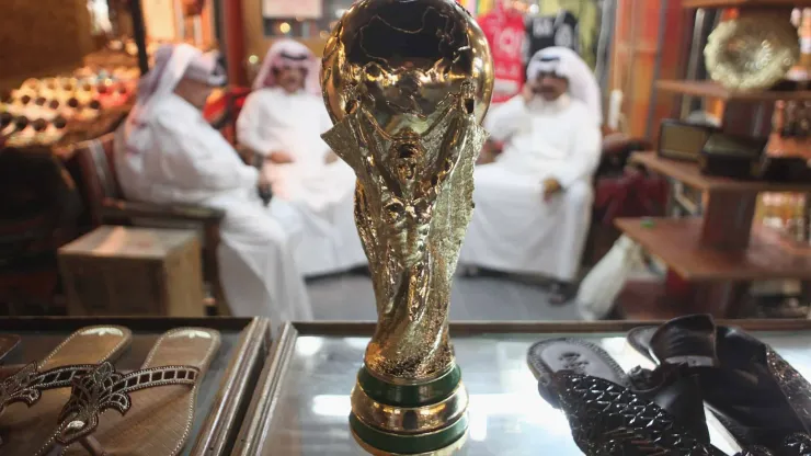 DOHA, QATAR – OCTOBER 24:  Arab men sit at a shoemaker's stall with a replica of the FIFA World Cup trophy in the Souq Waqif traditional market on October 24, 2011 in Doha, Qatar. Qatar will host the 2022 FIFA World Cup football competition and is slated to tackle a variety of infrastructure projects, including the construction of new stadiums.  (Photo by Sean Gallup/Getty Images)
