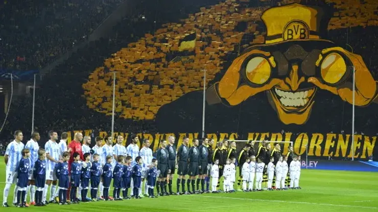 Dortmund's fans wave with yellow colours as the team pose for a family picture before the UEFA Champions League quarter-final second-leg football match Borussia Dortmund vs Malaga CF in Dortmund, western Germany on April 9, 2013. AFP PHOTO / ODD ANDERSEN (Photo credit should read ODD ANDERSEN/AFP/Getty Images)
