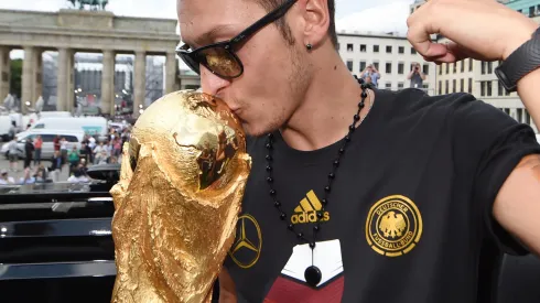 BERLIN, GERMANY – JULY 15: Mesut Oezil celebrates on the open top bus at the German team victory ceremony on July 15, 2014 in Berlin, Germany. Germany won the 2014 FIFA World Cup Brazil match against Argentina in Rio de Janeiro on July 13. (Photo by Markus Gilliar – Pool/Getty Images)