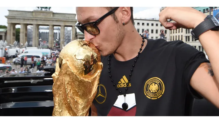 BERLIN, GERMANY – JULY 15: Mesut Oezil celebrates on the open top bus at the German team victory ceremony on July 15, 2014 in Berlin, Germany. Germany won the 2014 FIFA World Cup Brazil match against Argentina in Rio de Janeiro on July 13. (Photo by Markus Gilliar – Pool/Getty Images)