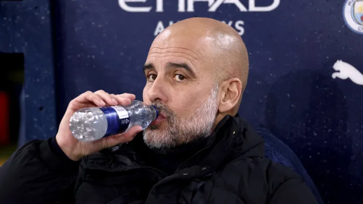 Pep Guardiola, Manager of Manchester City, has a drink prior to the Premier League match between Manchester City FC and Tottenham Hotspur FC at Etihad Stadium on November 23, 2024 in Manchester, England.