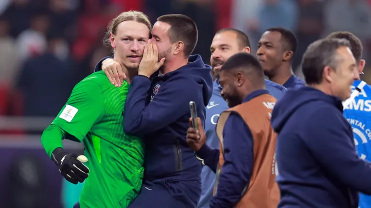 Matvey Safonov of Paris Saint-Germain is mobbed his teammates after they win the penalty shoot out during the FIFA Intercontinental Cup 2025.