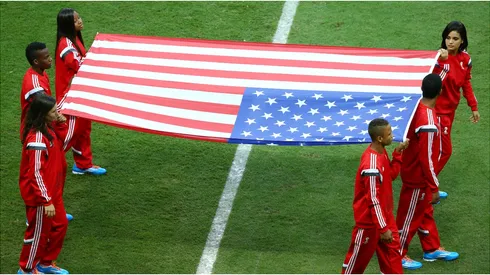 The United States flag is carried onto the field