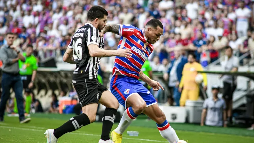 Jogador do Fortaleza disputa lance com jogador do Ceará, durante partida na Arena Castelão pelo Campeonato Cearense 2024. Foto: Kely Pereira/AGIF
