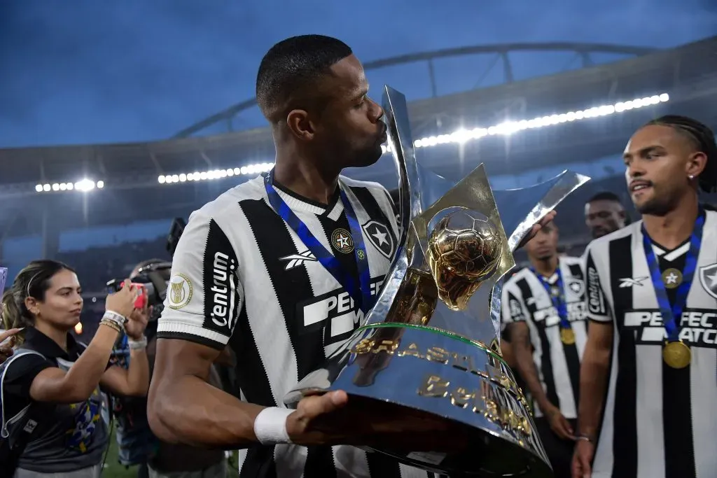 RJ – RIO DE JANEIRO – 08/12/2024 – BRASILEIRO A 2024, BOTAFOGO X SAO PAULO – Junior Santos jogador do Botafogo levanta a taca de campeao durante cerimonia de premiacao ao final da partida contra o Sao Paulo no estadio Engenhao pela decisao do campeonato Brasileiro A 2024. Foto: Thiago Ribeiro/AGIF
