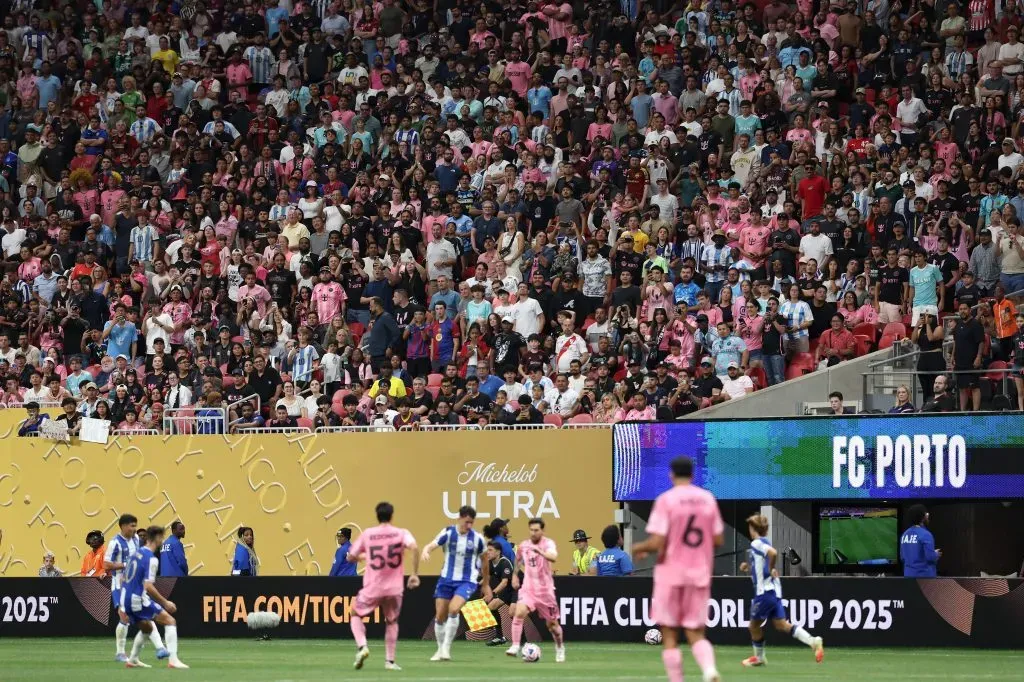 Torcedores do Inter Miami CF demonstram seu apoio nas arquibancadas, enquanto Lionel Messi, camisa 10 do Inter Miami CF, corre com a bola durante a partida do Grupo A da Copa do Mundo de Clubes da FIFA 2025 entre o Internacional CF Miami e o FC Porto, no Estádio Mercedes-Benz, em 19 de junho de 2025, em Atlanta, Geórgia. (Foto de Kevin C. Cox/Getty Images)