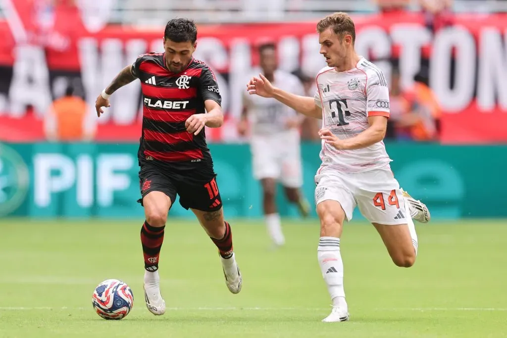 Giorgian de Arrascaeta, camisa 10 do CR Flamengo, corre com a bola sob pressão de Josip Stanisic, camisa 44 do FC Bayern München, durante a partida das oitavas de final da Copa do Mundo de Clubes da FIFA 2025 entre CR Flamengo e FC Bayern München no Hard Rock Stadium em 29 de junho de 2025 em Miami Gardens, Flórida. (Foto de Michael Reaves/Getty Images)