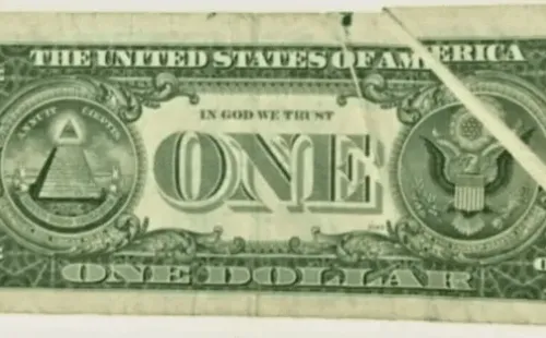 El dorso del billete de 1 dólar con un error de impresión en el vértice.