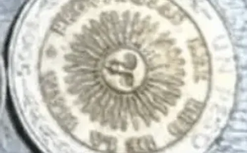 La moneda de un peso con el error de acuñación.