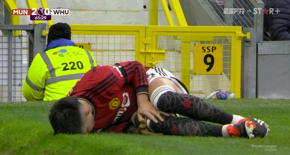Lisandro Martínez tendido en el césped del Old Trafford por la dolencia en su rodilla derecha.