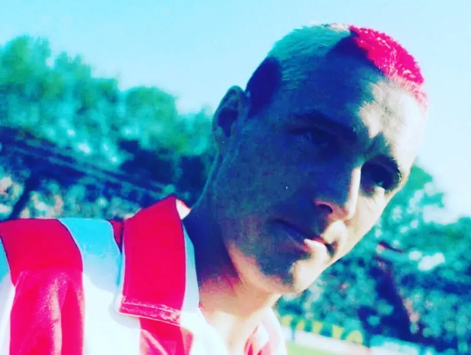 El famoso peinado de la pelota roja y blanca en su cabeza.