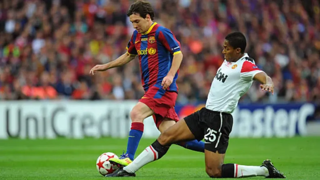 Lionel Messi of FC Barcelona and Luis Antonio Valencia of Manchester United (Photo by AMA/Corbis via Getty Images)