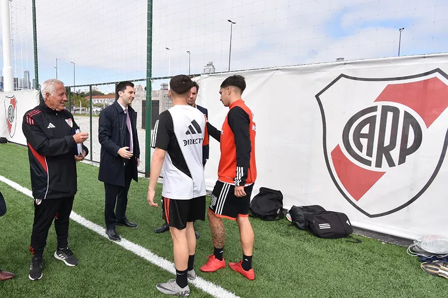 Gabriel Rodríguez (encargado del fútbol formativo), Stefano Di Carlo y Mariano Taratuty junto a los chicos en el predio de Cantilo. (Foto: Prensa River).
