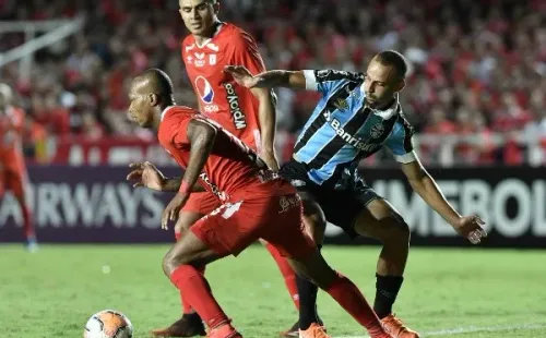Thaciano tenta levar a melhor sobre Edwin Velasco, do América de Cali. Foto: Getty Images