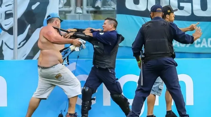 Torcedores do Grêmio invadiram o gramado da Arena após o apito final (Foto: Pedro H. Tesch/AGIF)