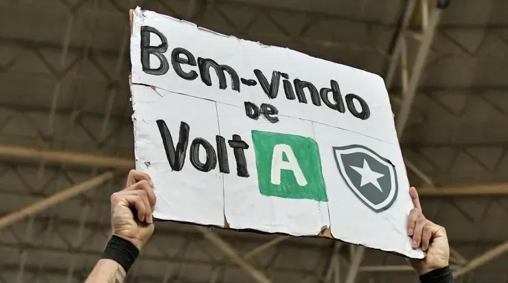 Torcedor do Botafogo exibe cartaz celebrando a volta do time à Série A (Foto: Thiago Ribeiro/AGIF)