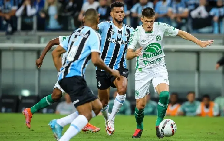 Pedro H. Tesch/AGIF – Perotti na disputa pela bola com jogadores do Grêmio