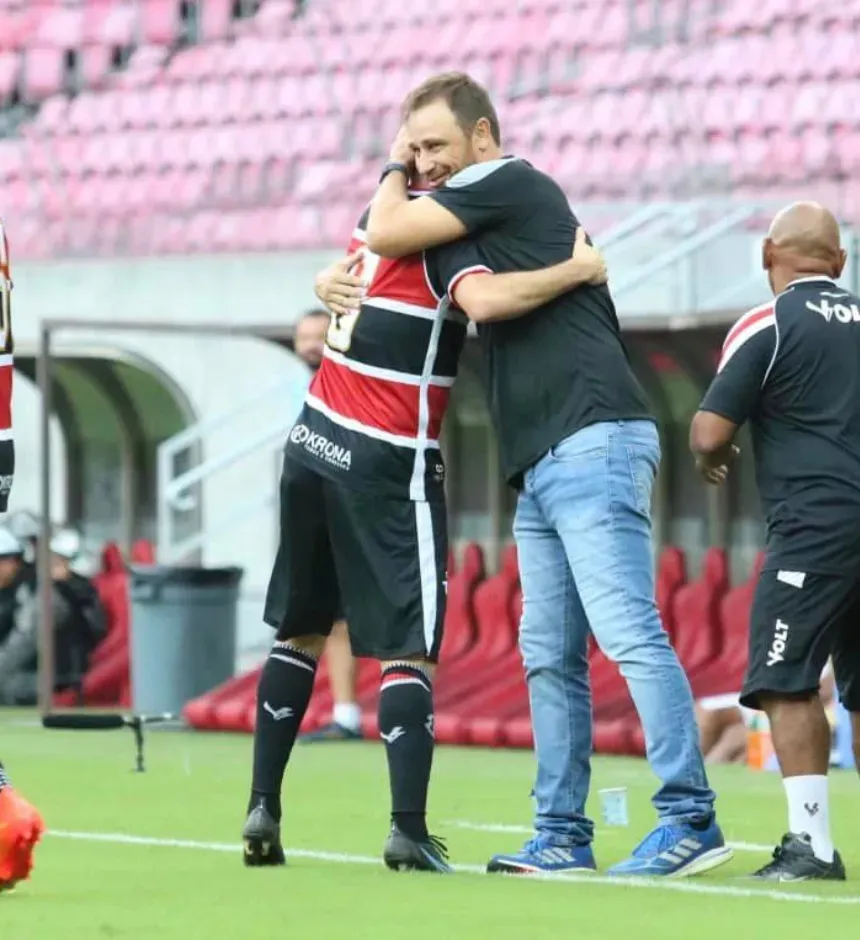 Foto: Reprodução Redes Sociais do Santa Cruz – Jogador Pipico abraça o técnico, Felipe Conceição, após marcar três gols em partida contra o Petrolina