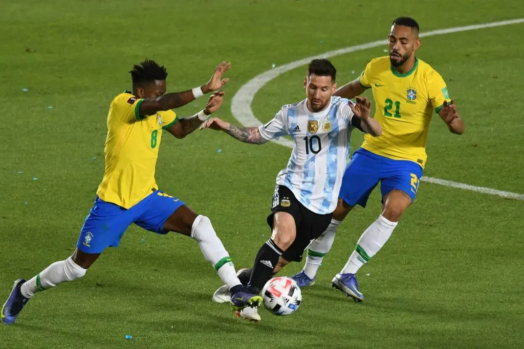 Messi jogador do Argentina disputa lance com Fred e Matheus Cunha jogadores do Brasil durante partida no estádio San Juan del Bicentenario pelo campeonato Eliminatórias Copa do Mundo 2022.  FotoBaires/AGIF