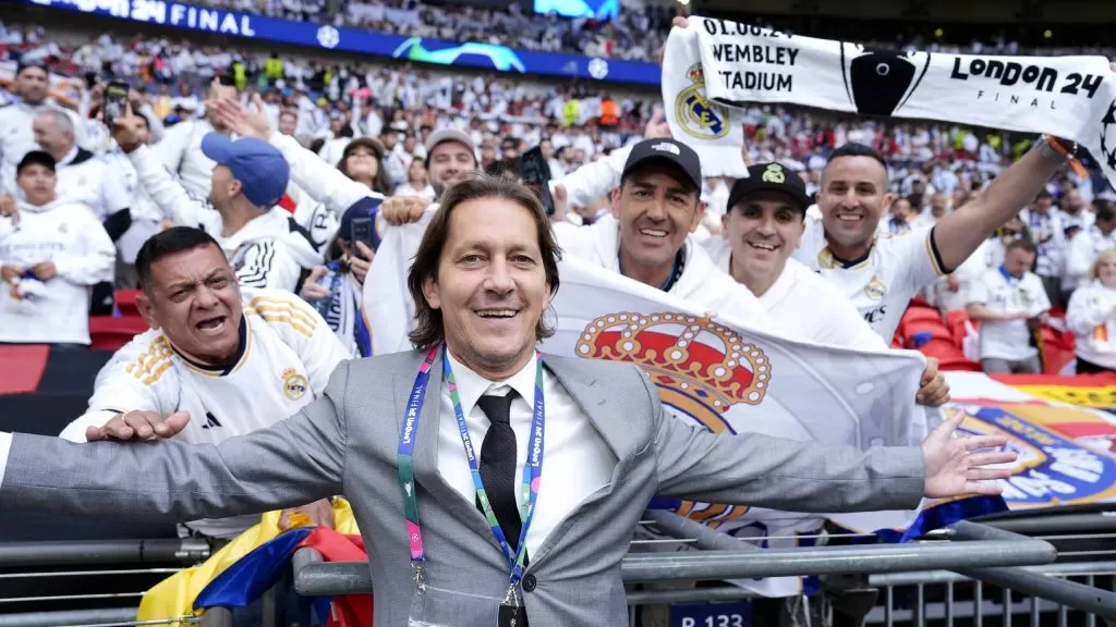 Michel Salgado de terno ao fundo com torcedores do Real e bandeira do clube - Foto: x Nick Potts