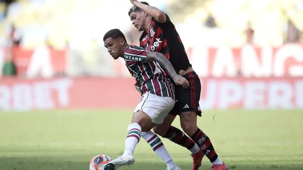 Riquelme Felipe jogador do Fluminense disputa lance com Ayrton Lucas jogador do Flamengo durante partida no estádio Maracanã pelo campeonato Carioca 2025. Foto: Alexandre Loureiro/AGIF
