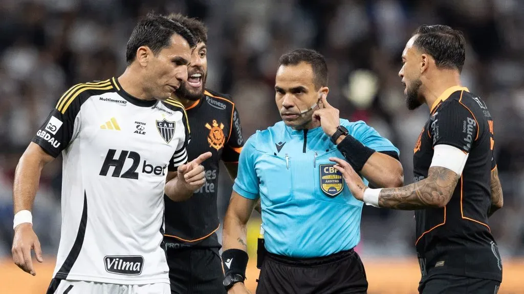 O arbitro Alex Gomes Stefano escuta VAR durante partida entre Corinthians e Atletico-MG no estadio Arena Corinthians pelo campeonato Brasileiro A 2025. Foto: Joisel Amaral/AGIF